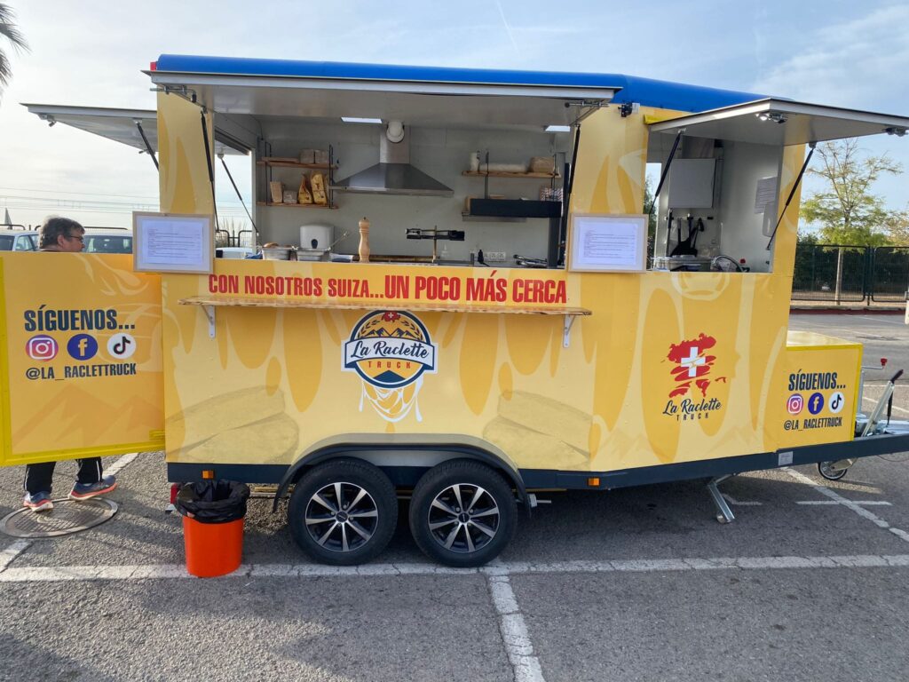 vista lateral de laraclette foodtruck estacionado listo para servir en un evento.
