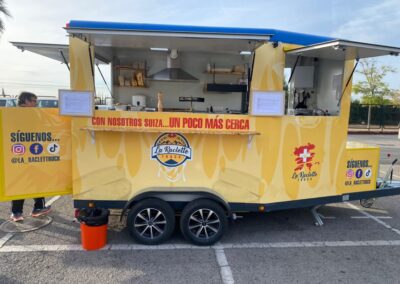 vista lateral de laraclette foodtruck estacionado listo para servir en un evento.