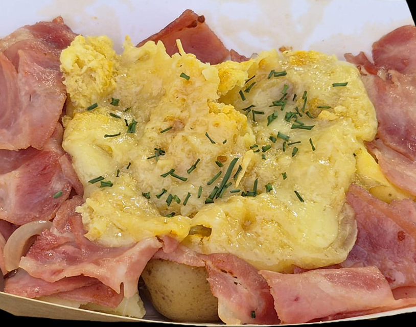 Plato de patata con queso raclette fundido y lacón a la plancha