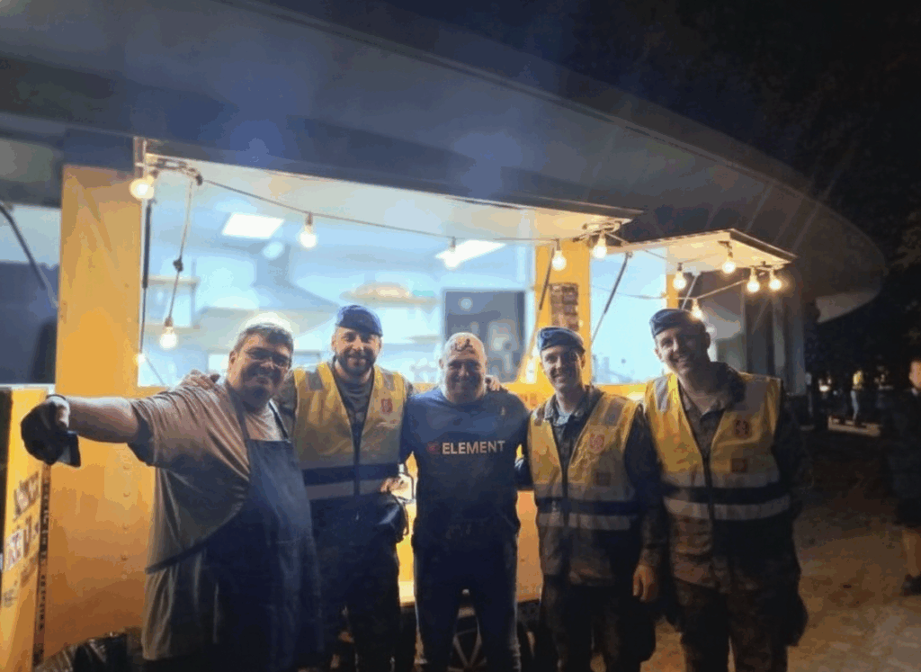 Equipo de La Raclette y militares frente a la foodtruck iluminada durante la DANA.