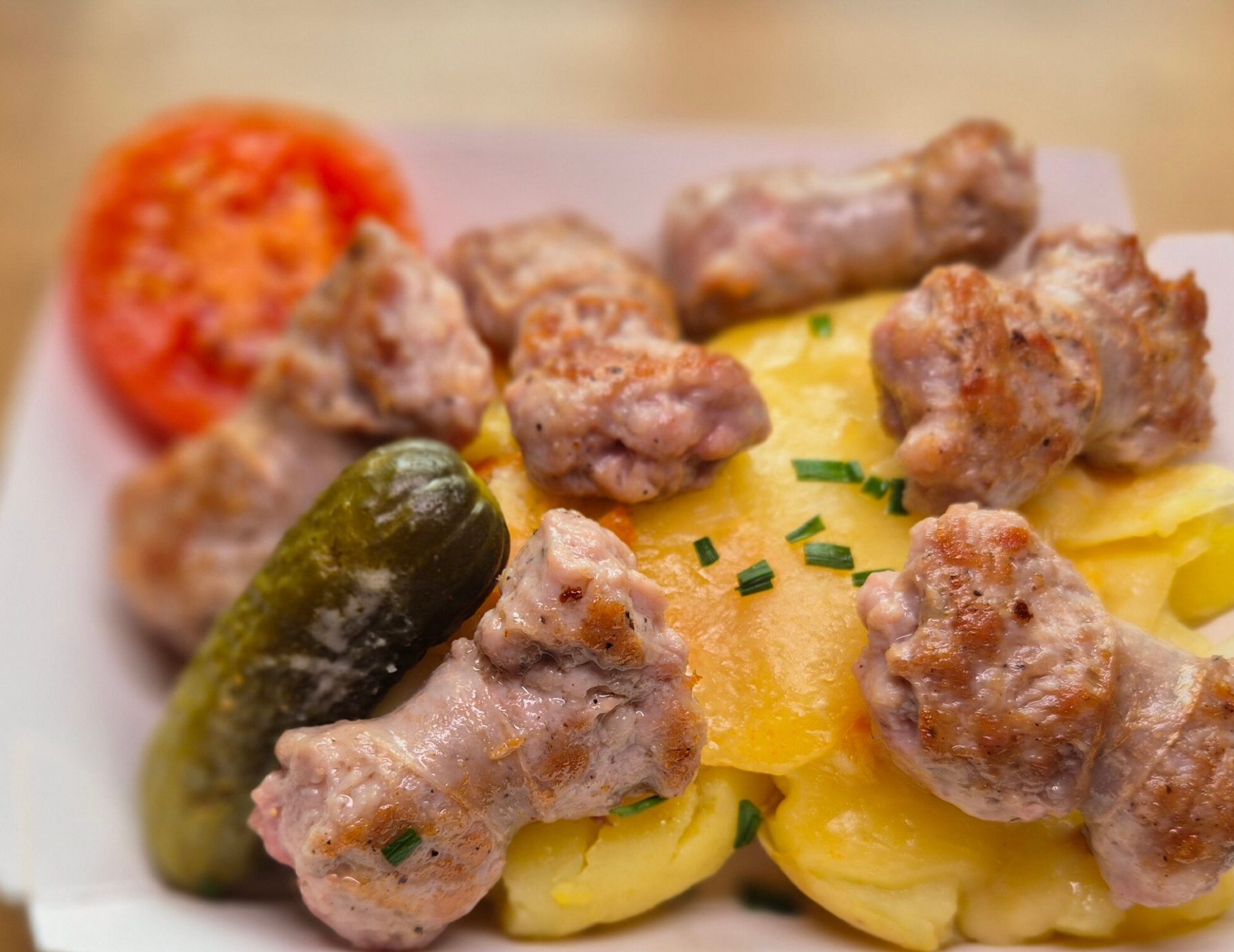 Raclette servida con butifarra salteada y queso fundido.