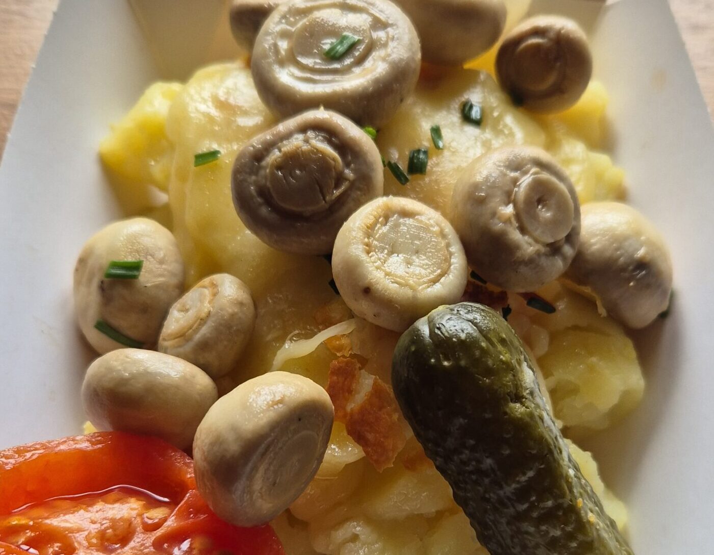 plato de patata con queso raclette fundido y champiñones salteados