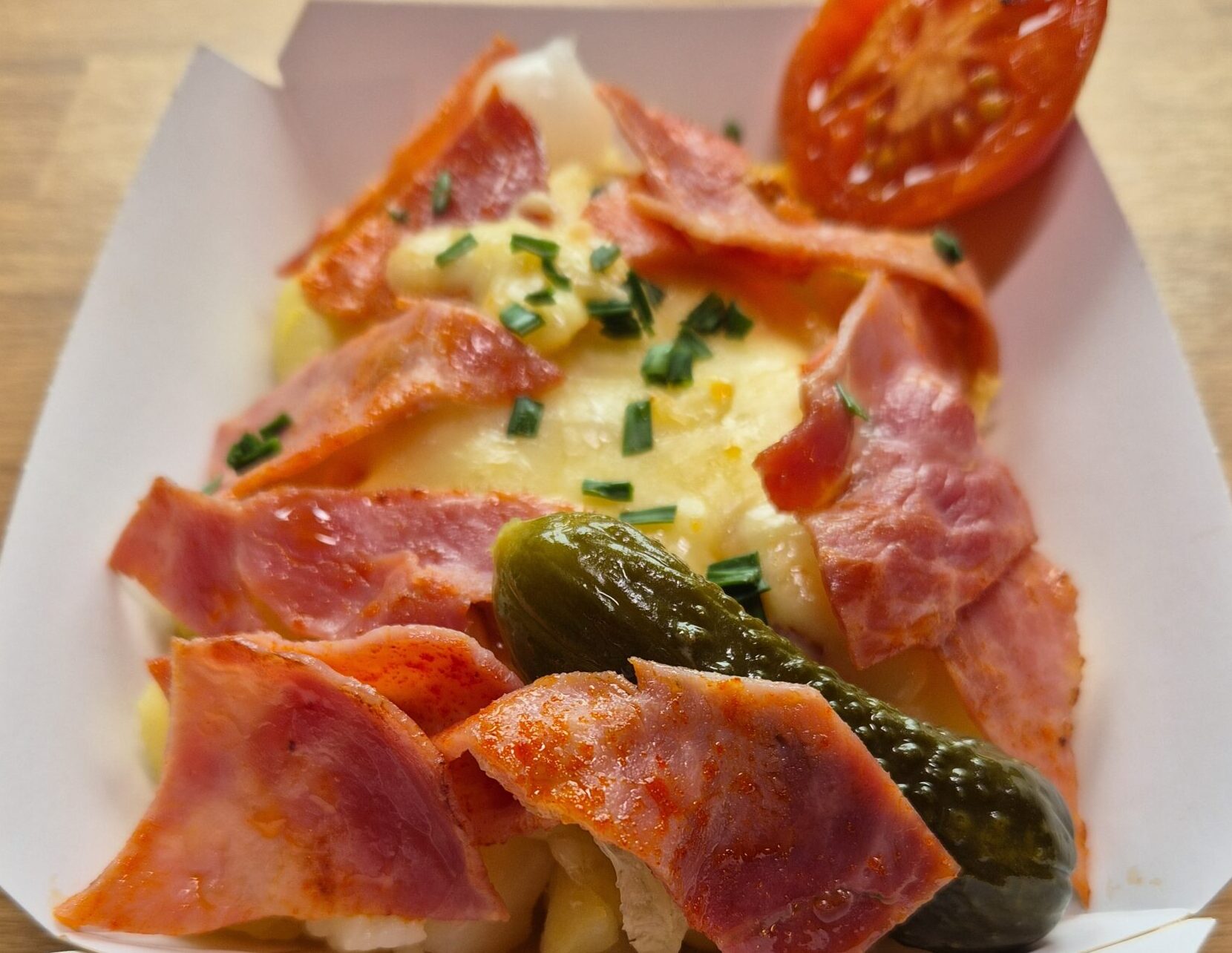 Plato de patata con queso raclette fundido y lacón a la plancha